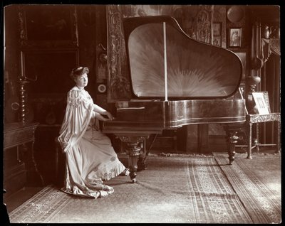 Sra. I. M. Clark sentada en un piano de cola, 1904 de Byron Company